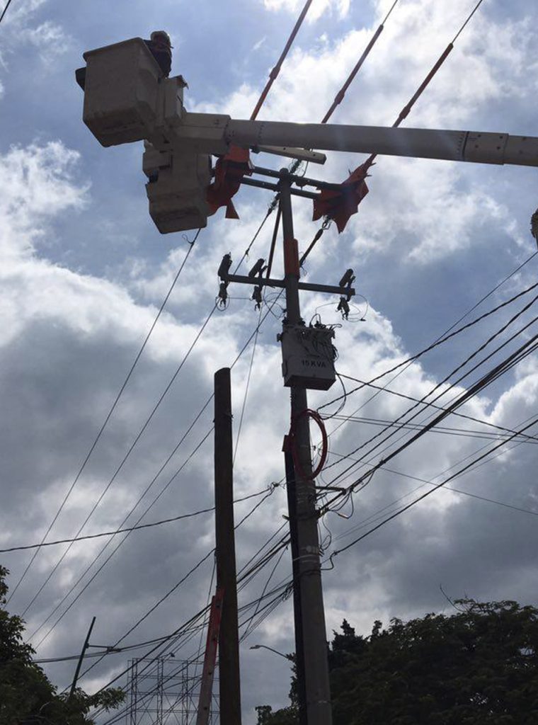 Low angle view of electrician in gloves fixing electrical distri
